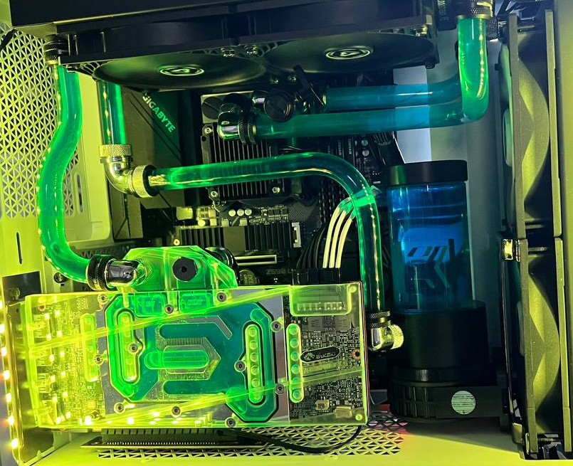 Green-lit rigid tubes and transparent water blocks inside a white PC case