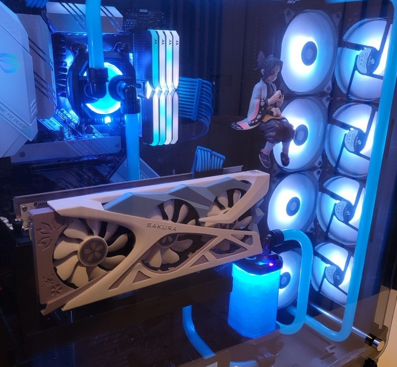 White graphics card with visible fans beside blue coolant tubing and reservoir