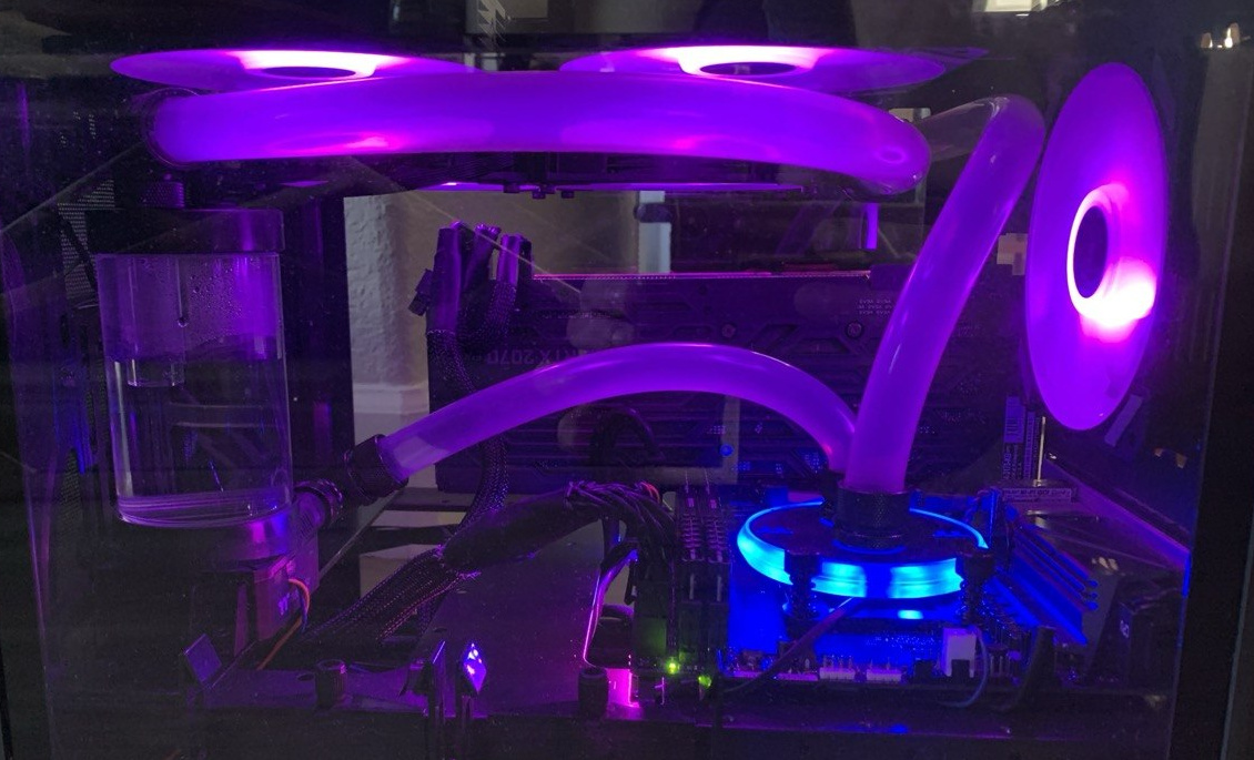 Purple-lit PC interior with flexible tubes, reservoir and a rear fan