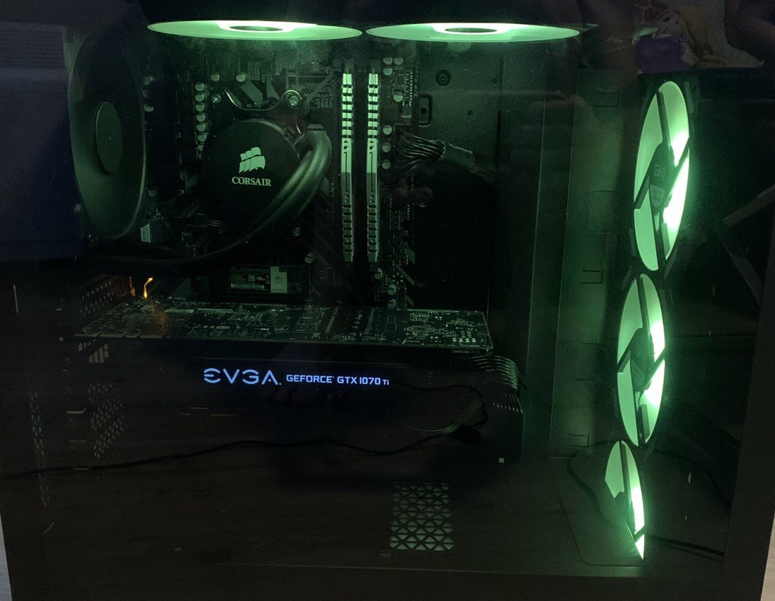 Dark PC interior with green-lit top and front fans
