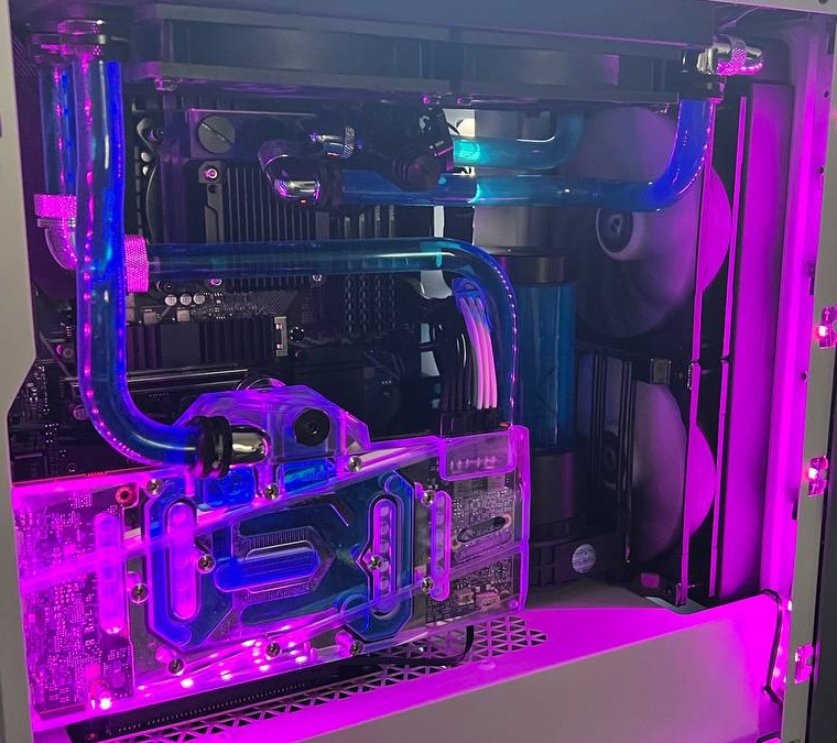 Purple-lit PC interior with rigid cooling tubes and transparent water blocks