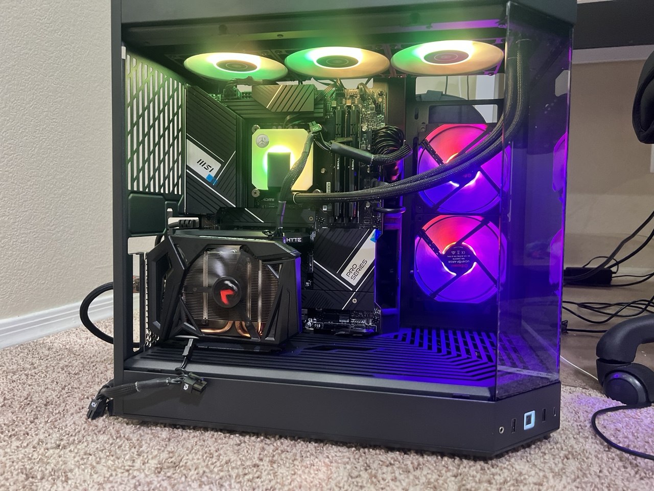 Black PC with green-lit fans, purple lighting and curved cooling tubes